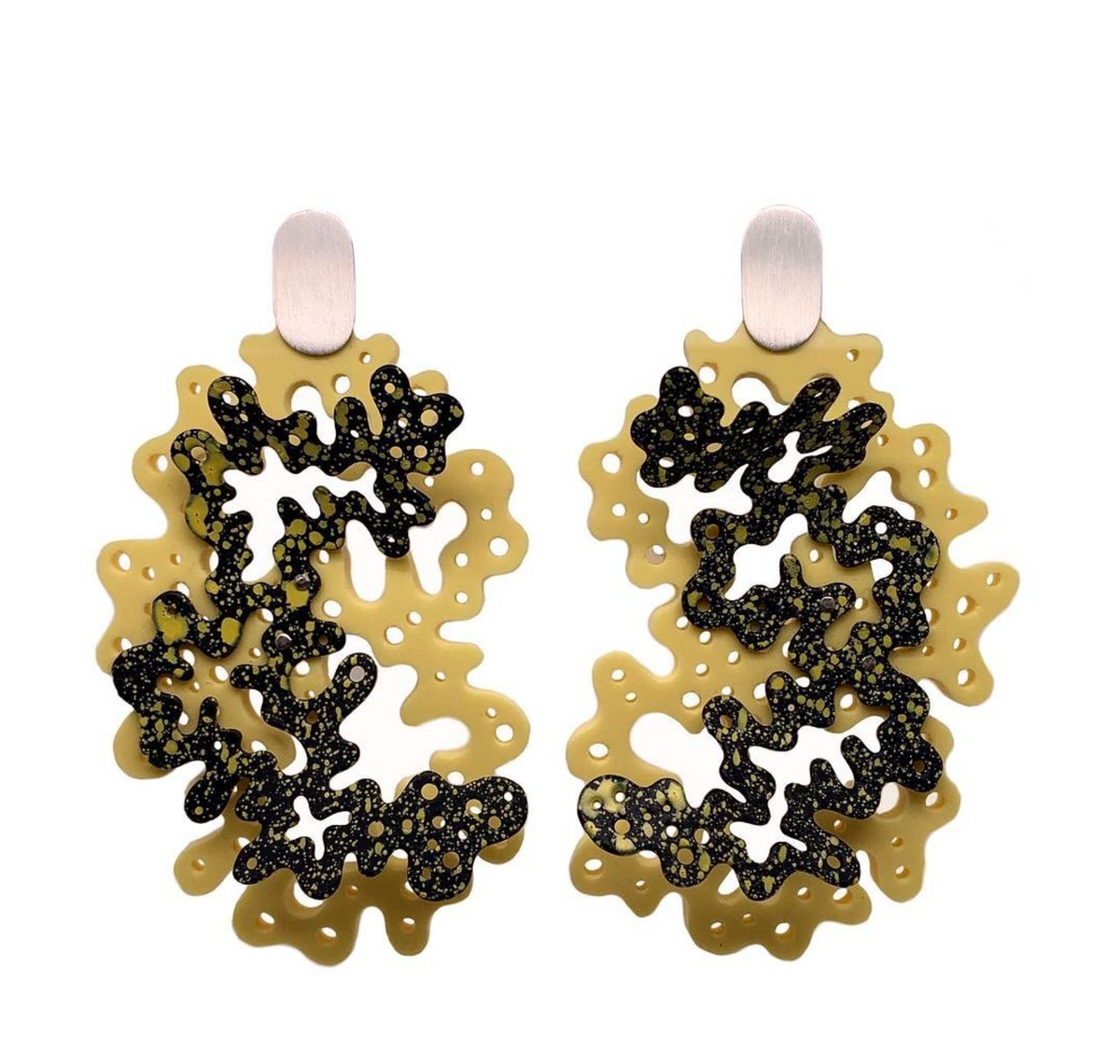 A pair of statement earrings featuring organic, wavy shapes with a matte gold base and textured black glittery inlay, suspended from simple brushed silver posts on a white background.